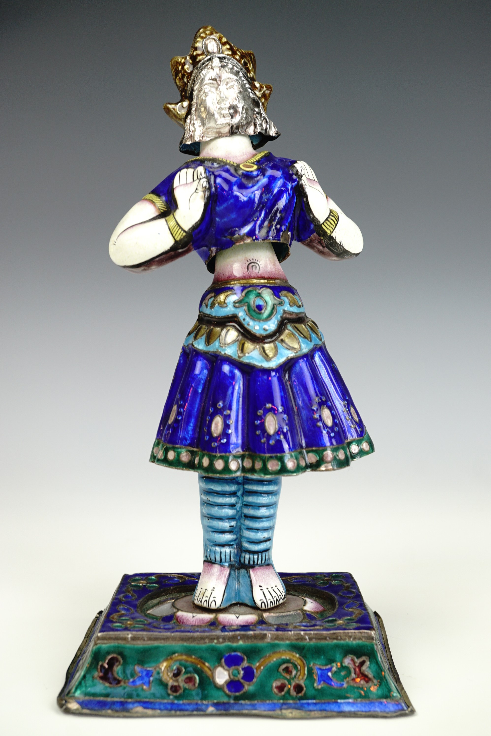 An early 20th century Indian enamelled white metal figurine of a dancer, formed in four sections,