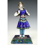 An early 20th century Indian enamelled white metal figurine of a dancer, formed in four sections,