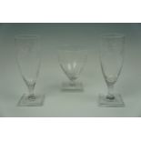 A pair of William Yeowood champagne flutes and a matching goblet, with engraved grape and vine