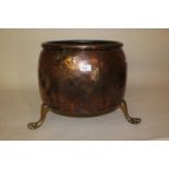 Copper cauldron form log bin on three outswept paw supports, 16ins diameter