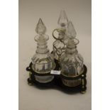 19th Century brass mounted black lacquered decanter stand with three various cut glass decanters