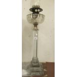 Early 20th Century glass oil lamp with a cut glass well, on hexagonal column and stepped platform