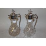 Pair of silver mounted cut glass claret jugs, the hinged covers with lion finials (glass neck to one