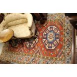 20th Century Turkish carpet of Kazak design with a triple hooked medallion pattern on a terracotta