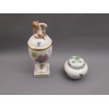 Royal Copenhagen floral decorated pedestal jar and cover, surmounted by a figure of seated putto,