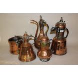 Two Middle Eastern copper flagons with hinged lids, two similar smaller vessels and another with