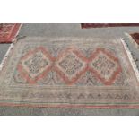 Pakistan rug of Caucasian design with a triple medallion pattern on a pale pink ground, 6ft x 4ft