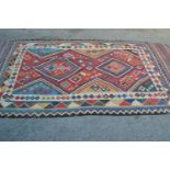 Kelim rug with a twin medallion design on a red ground with borders, 9ft 8ins x 5ft 4ins