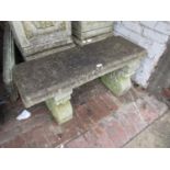 Weathered cast concrete garden bench with a slab top on two scroll shaped supports, 38ins wide