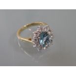 18ct Yellow and white gold oval aquamarine and diamond cluster ring, the aquamarine approximately
