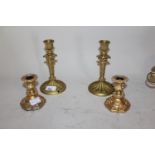 Pair of Regency ormolu candlesticks, 7.25ins high (drilled to bases) together with a pair of later