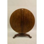 Victorian circular rosewood tilt top centre table on a turned column and triform base with carved