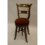 Regency rosewood and cut brass inlaid music chair, the rail back above a circular swivel seat,