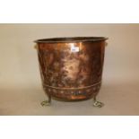 Riveted copper log bin on three brass paw supports, 17.5ins diameter