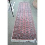 Pakistan runner of Bokhara design with two rows of gols on a pink ground, 10ft x 2ft 10ins