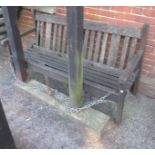 Weathered slatted teak garden bench of traditional design