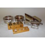 Pair of plate on copper bottle coasters, seven piece silver mounted dressing table set and a cased