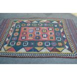 Antique Kelim rug with a polychrome geometric design in shades of rose pink, green, blue, cream