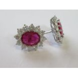 Pair of 18ct white gold oval ruby and diamond cluster ear studs, the rubies of approximately 3.