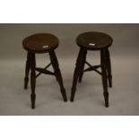 Pair of 19th Century circular elm stools on turned supports with crossover stretcher