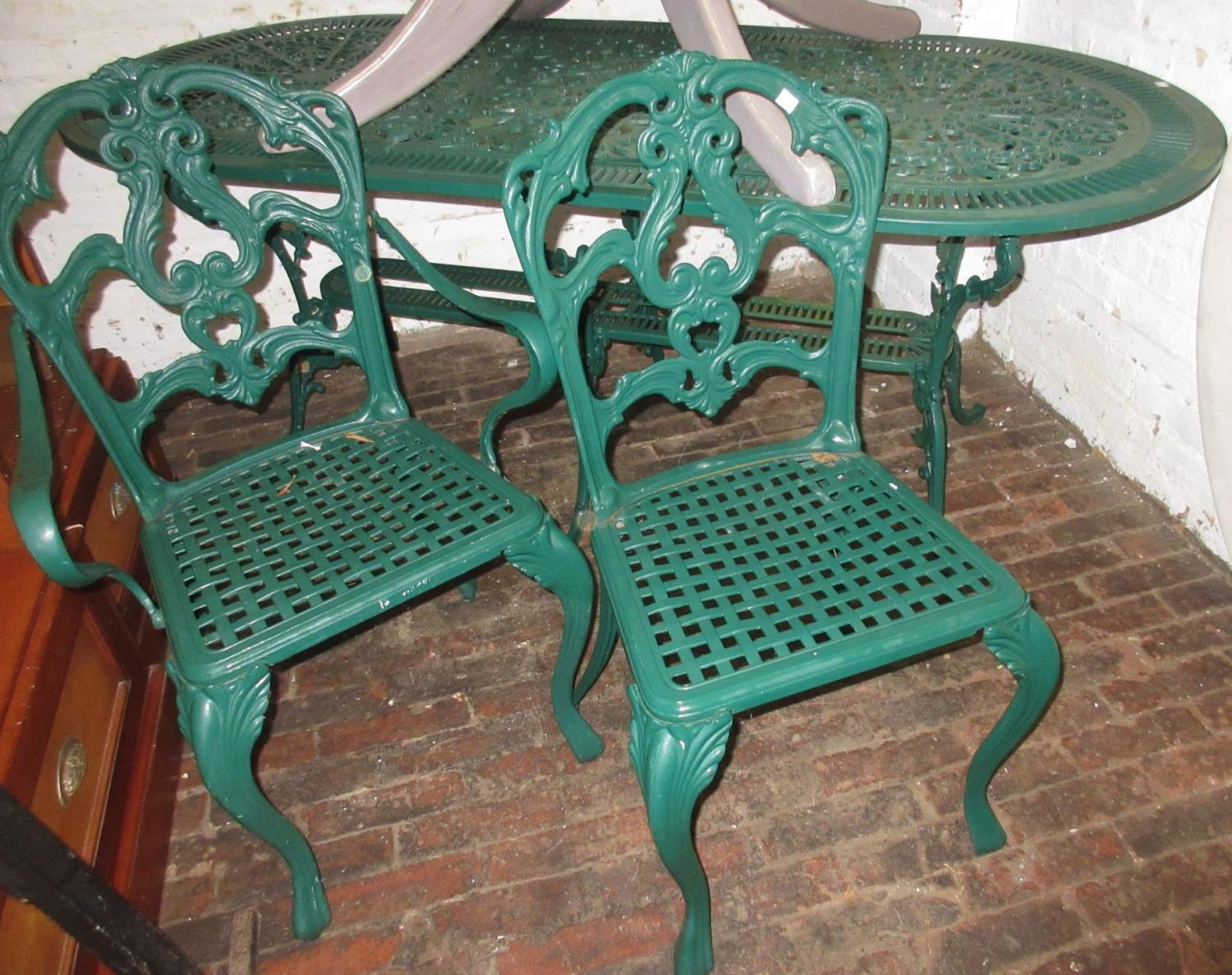 Green painted cast alloy garden table together with a set of four (three plus one) matching chairs