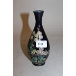 Cloisonne baluster form vase with narrow neck decorated with white and yellow flowers on a dark blue