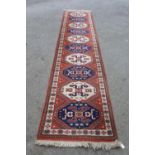 Modern Turkish runner with a repeating medallion design on a terracotta ground with borders, 12ft