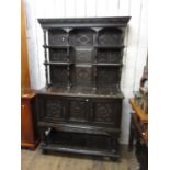 Antique carved oak side cabinet with a moulded cornice above open shelves on spindle supports, the