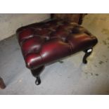 20th Century red leather button upholstered rectangular footstool on ebonised cabriole supports,