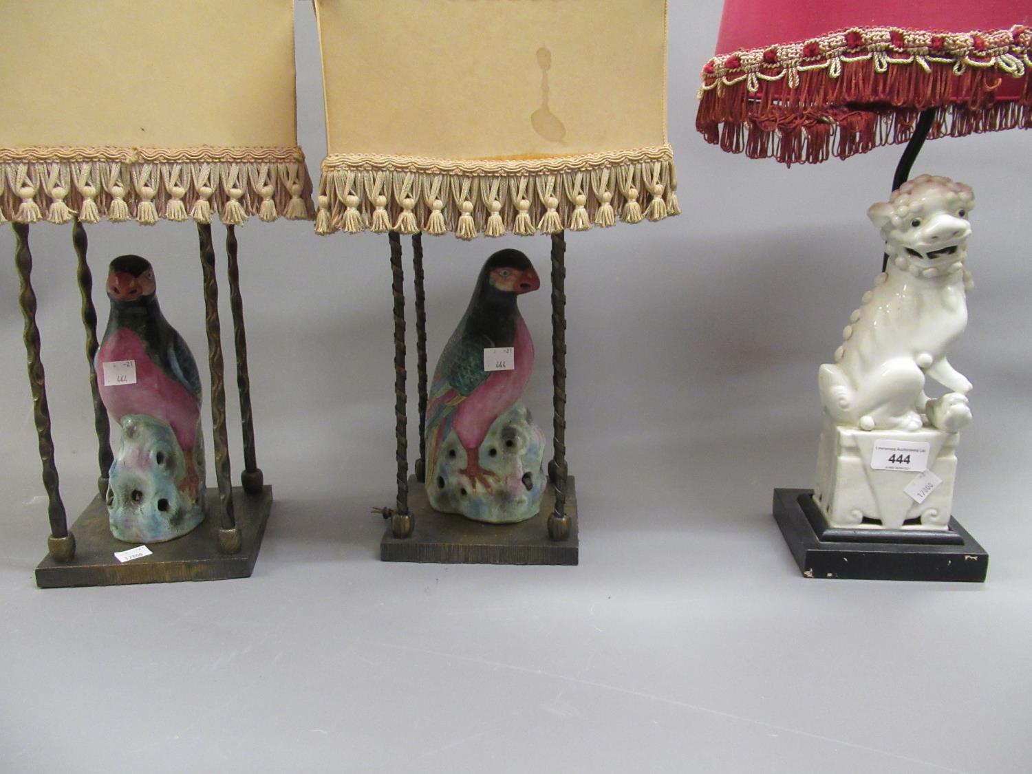 Pair of table lamps in the form of porcelain figures of birds in decorative gilt brass cage form