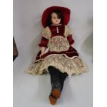 Wax shoulder plate doll with fixed brown eyes and wax arms, wearing a red velvet lace trimmed