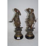 Pair of French spelter figures with painted patinated finish, on circular ebonised wooden plinth