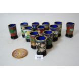 Set of twelve Chinese small cloisonne floral decorated beakers on hardwood stands, with blue