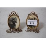 Pair of miniature silver gilt oval photograph frames with integral back stands on scroll supports,