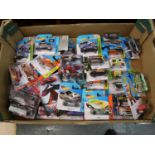 Box of various modern Hot Wheels model vehicles in original blister packs