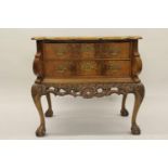 Continental burr walnut commode chest on stand, the top with herringbone inlay and shaped edge above