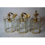 Set of three modern gilt brass hexagonal lantern form light fittings, 12ins high excluding chain