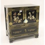 Small 20th Century oriental black lacquer side cabinet with two doors applied with soapstone