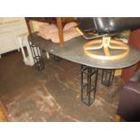 Contemporary wrought iron dining room table with an oval reconstituted stone top above four square