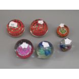 Caithness Desert Spring pattern glass paperweight together with a pair of glass paperweights and