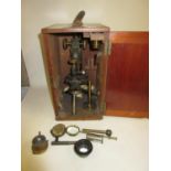 Watson & Sons black japanned and gilt brass monocular microscope with accessories, in a mahogany