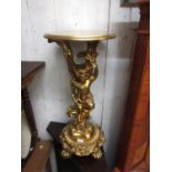 Modern reproduction gilded composition torchere in the form of putto together with a similar wall