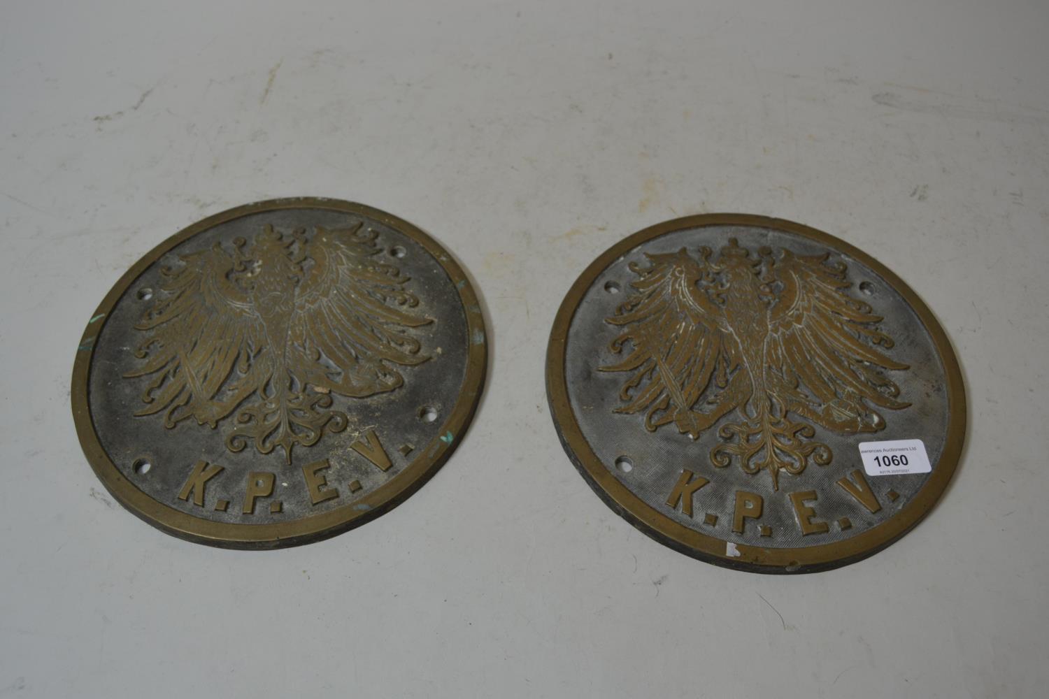 Pair of East European circular brass wall plaques decorated in relief with a spread eagle above