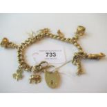 9ct Gold hollow curb link charm bracelet with padlock clasp and various charms Weight - 52g gross