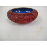 Chinese red cinnabar lacquer bowl relief decorated with figures in a landscape, the interior in blue