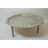 Middle Eastern silver plated Decagon tray with floral chased decoration, raised on three later brass