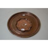 Small shaped hand beaten copper dish, 9ins diameter and an earlier copper dish with engraved