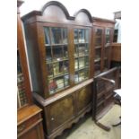Early to mid 20th Century walnut bookcase, the double dome top with a pair of bar glazed doors