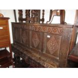 17th Century oak coffer, the hinged four panel lid above a carved frieze and four panel front,