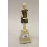 Dimitri Chiparus, small gilt bronze and carved ivory figure of a standing girl on an onyx plinth